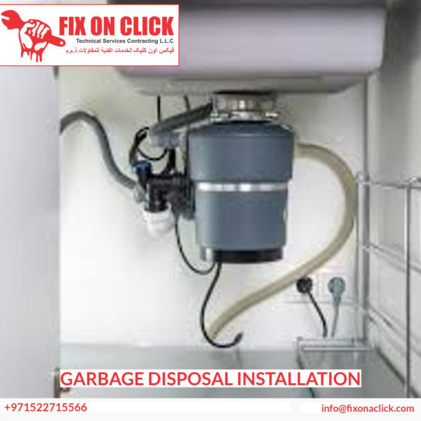 Technician connecting garbage disposal unit to sink drain and dishwasher in Dubai kitchen