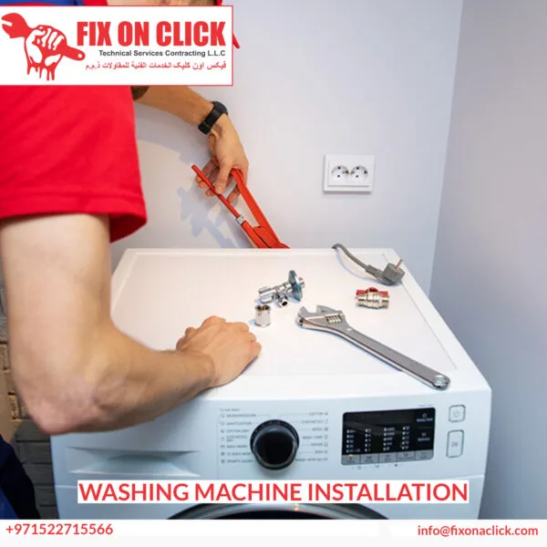 Technician connecting washing machine water supply and drain hoses in Dubai property