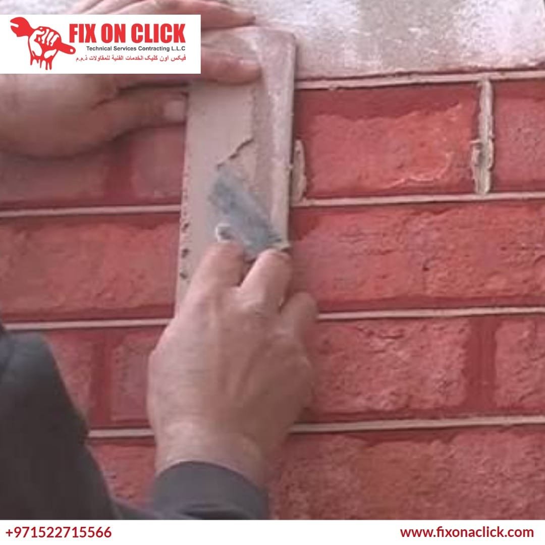 Professional mason performing tuckpointing on a brick wall