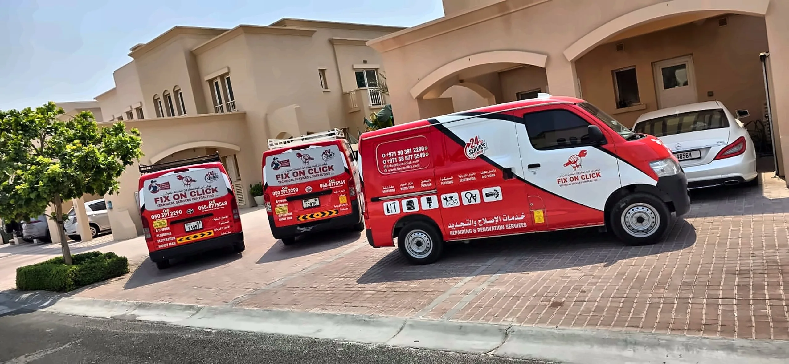 Three Fix On Click service vans parked outside a villa in Dubai